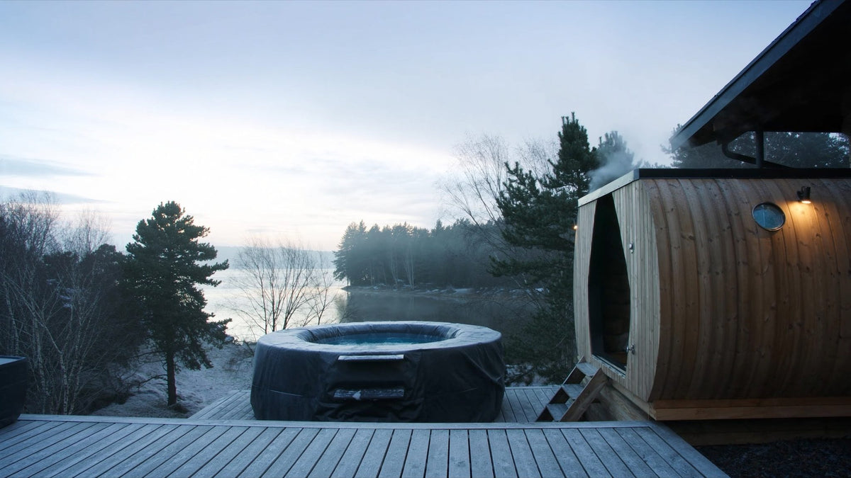 Barrel sauna and cold plunge on a lakeside deck on a winter morning